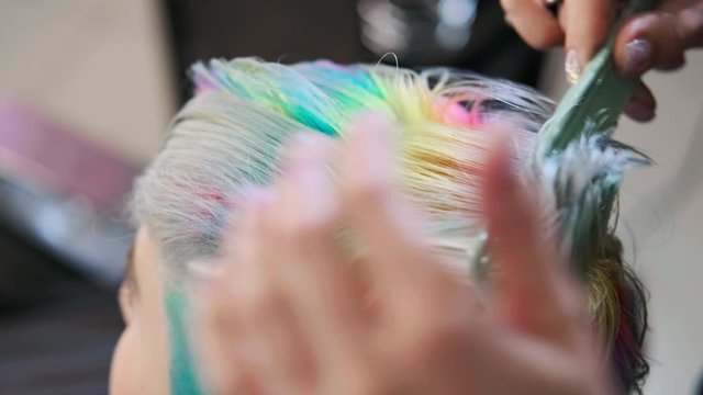 Coloring hair in a barbershop. Multicolored dyeing. A short pixie haircut.