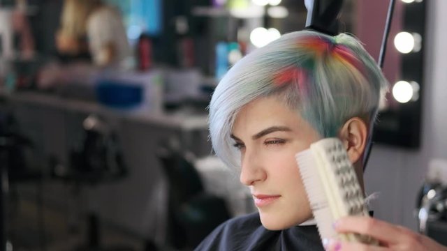 Coloring hair in a barbershop. Multicolored dyeing. A short pixie haircut.