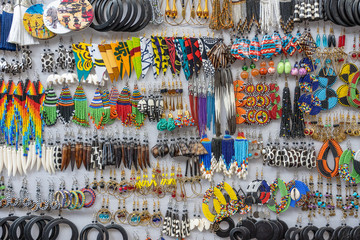 Tribal masai colorful earrings for sale for tourists at the beach market, close up. Island of Zanzibar, Tanzania, Africa