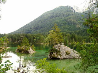 Beautiful scene of trees on a rock island in idyllic scenery at charming Lake Hintersee in summer Berchtesgaden Germany