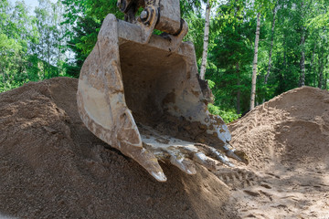 excavator digs clay soil at the construction site
