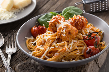 Traditional italian pasta served on a old wooden table. Pasta with Meatballs, parmesan cheese and herbs. Homemade delicious italian traditional pasta on on a rustic table for dinner. italian cuisine.