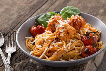 Traditional italian pasta served on a old wooden table. Pasta with Meatballs, parmesan cheese and herbs. Homemade delicious italian traditional pasta on on a rustic table for dinner. italian cuisine.