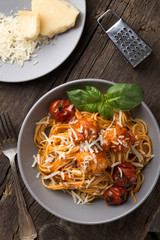 Traditional italian pasta served on a old wooden table. Pasta with Meatballs, parmesan cheese and herbs. Homemade delicious italian traditional pasta on on a rustic table for dinner. italian cuisine.