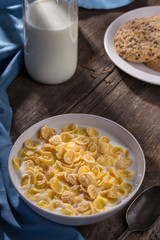 Breakfast with cereal. Flakes with milk. A plate of cereal with milk on a old wooden table. Perfect for breakfast. Free space for text.