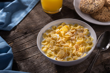 Breakfast with cereal. Flakes with milk. A plate of cereal with milk on a old wooden table. Perfect for breakfast. Free space for text.