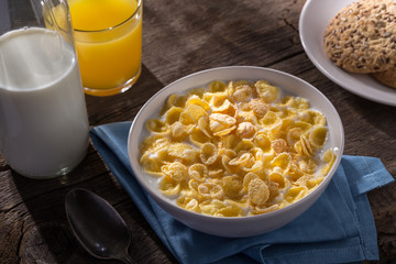 Breakfast with cereal. Flakes with milk. A plate of cereal with milk on a old wooden table. Perfect for breakfast. Free space for text.