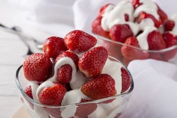 Strawberries with cream for two. Served on the table. Perfect for breakfast. Close-up shot. Free space for text.