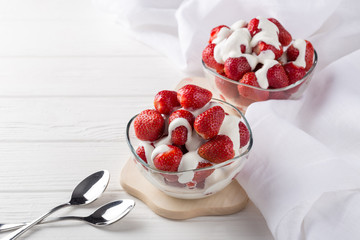 Strawberries with cream for two. Served on the table. Perfect for breakfast. Close-up shot. Free space for text.