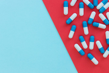 Drugs pills capsules on red blue background abstract top view medicine health concept