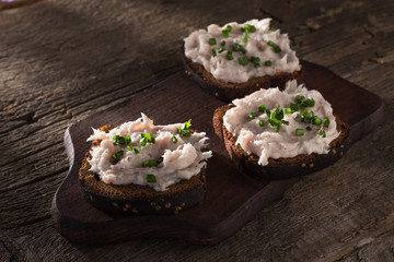 Bruschetta with lard. Bruschette with pate. Bruschette served on an old wooden table. Morning light. Morning breakfast. Close-up shot. Free space for text.