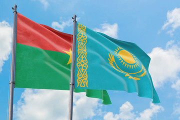 Kazakhstan and Burkina Faso flags waving in the wind against white cloudy blue sky together. Diplomacy concept, international relations.