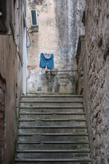 Kotor, Montenegro - June 25, 2018: Narrow street end stairs and pants on the rope
