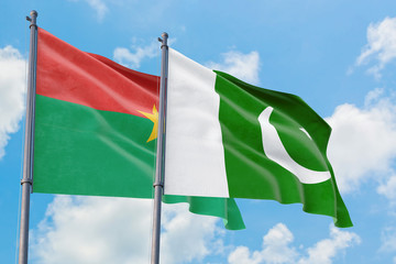 Pakistan and Burkina Faso flags waving in the wind against white cloudy blue sky together. Diplomacy concept, international relations.