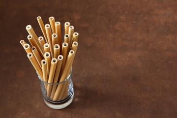 bamboo straw on old wood table background with copy space ( straw from natural material / green product concept )