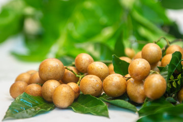 Some wampee and green leaves on a white background.