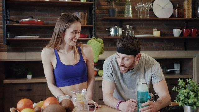 Close Up View Of Beautiful Young Caucasian Woman In Fitness Wear Meeting Her Sweaty Tired Man Coming Home After The Training, Discussing The Workout, Hardly Breathing. Happiness, Health Concept