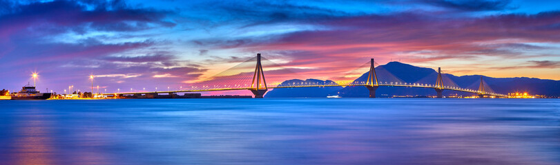 Sunset view on the bridge near Patras. Suspension bridge crossing Corinth Gulf strait, Greece, Europe. Second longest cable-stayed bridge in the world. Dramatic red sky under a Rion-Antirion Bridge.