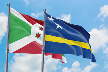 Fototapeta na wymiar Curacao and Burundi flags waving in the wind against white cloudy blue sky together. Diplomacy concept, international relations.