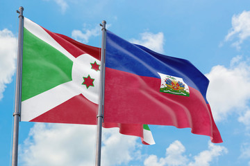 Haiti and Burundi flags waving in the wind against white cloudy blue sky together. Diplomacy concept, international relations.