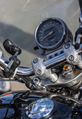 Motorcycle speedometer calibrated in miles and kilometers.Partially with steering wheel and tank