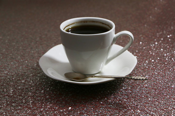 A cup of coffee in the evening on a dark background.