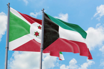 Kuwait and Burundi flags waving in the wind against white cloudy blue sky together. Diplomacy concept, international relations.