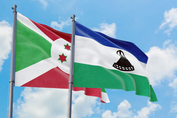 Lesotho and Burundi flags waving in the wind against white cloudy blue sky together. Diplomacy concept, international relations.