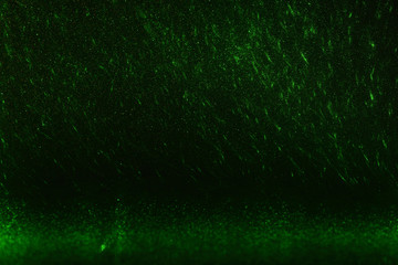 Green rays, lightning and glitter on a black background