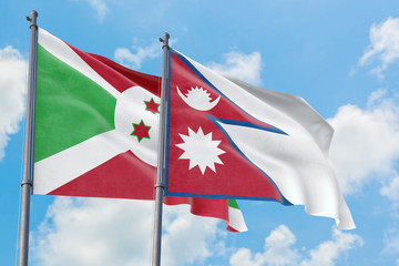 Nepal and Burundi flags waving in the wind against white cloudy blue sky together. Diplomacy concept, international relations.