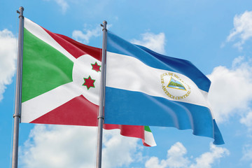 Nicaragua and Burundi flags waving in the wind against white cloudy blue sky together. Diplomacy concept, international relations.
