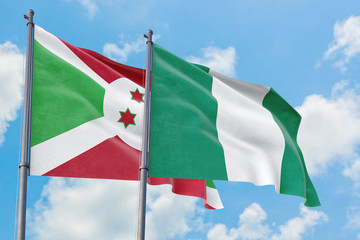 Nigeria and Burundi flags waving in the wind against white cloudy blue sky together. Diplomacy concept, international relations.