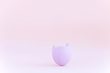 Purple easter eggshell on pastel pink background. Egg is a symbol of the celebration of a religious holiday among Catholics, Christians and Protestants
