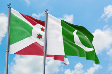 Pakistan and Burundi flags waving in the wind against white cloudy blue sky together. Diplomacy concept, international relations.
