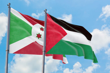 Palestine and Burundi flags waving in the wind against white cloudy blue sky together. Diplomacy concept, international relations.