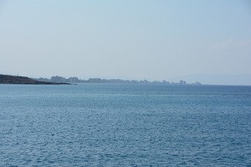 Tall houses of the city on the beach in the distance