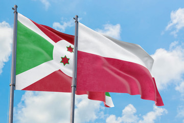 Poland and Burundi flags waving in the wind against white cloudy blue sky together. Diplomacy concept, international relations.