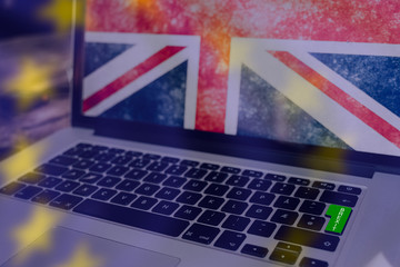 Green button on computer for brexit, union jack on the screen and the stars from the EU flag as...