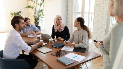 Multiracial colleagues discuss ideas at office briefing