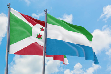 Fototapeta na wymiar Sierra Leone and Burundi flags waving in the wind against white cloudy blue sky together. Diplomacy concept, international relations.