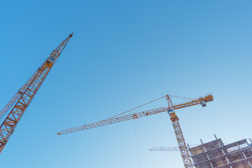 Construction site with high-rise construction cranes.