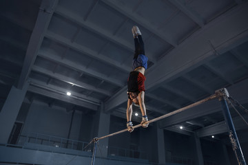 Little male gymnast training in gym, flexible and active. Caucasian fit little boy, athlete in...