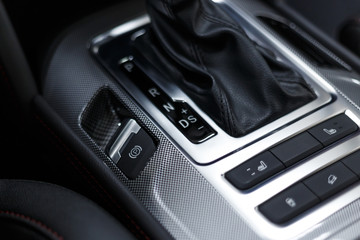 Fototapeta premium Leather car interior. Modern car illuminated dashboard. Luxurious car instrument cluster. Close up shot of automobile instrument panel. Modern car interior dashboard. Electric hand brake