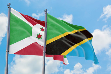 Tanzania and Burundi flags waving in the wind against white cloudy blue sky together. Diplomacy concept, international relations.