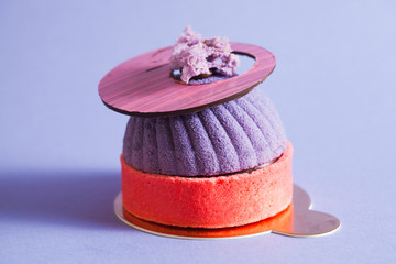 French pastry decorated with purple mirror glaze. Modern european cake with blueberry mousse.