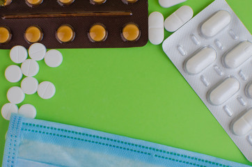 Text phrase Coronavirus on a green background with medicines and protective masks. Novel...