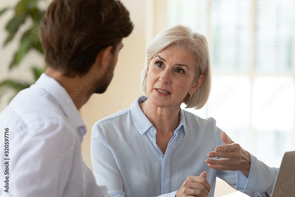 Poster Serious diverse businesspeople talk discuss ideas at meeting