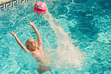 Pretty little girl in swimming pool, summer vacations.