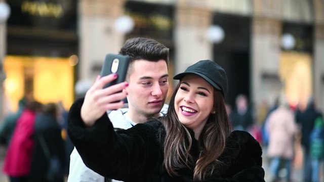 Couple of tourists taking funny selfies in Milan