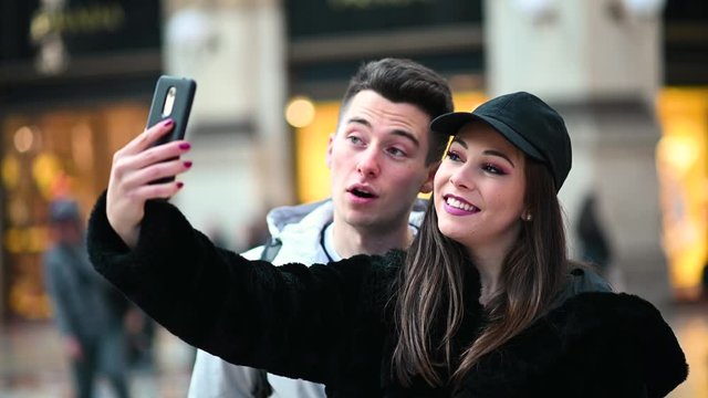 Couple of tourists taking funny selfies in Milan